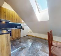Küche in einer 4-Zimmer-Wohnung mit Holzdekor und hellem Dachfenster im Dachgeschoss.
