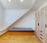 Schlafzimmer in einer 4-Zimmer-Wohnung mit Holzboden und Stauraum.