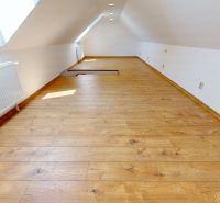 Dachgeschosszimmer in einer 4-Zimmer-Wohnung mit Holzboden und Dachfenstern.