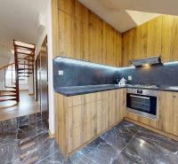 Küche in einer 4-Zimmer-Wohnung mit Holzdekorboden und Wendeltreppe.