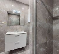 Badezimmer in einer 4-Zimmer-Wohnung mit Fliesen und Duschkabine, elegante weiße Schrank.