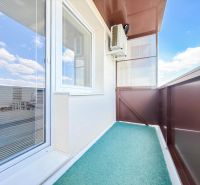 Balkon einer 2-Zimmer-Wohnung in Nitra mit Blick auf den Himmel und Klimaanlage.