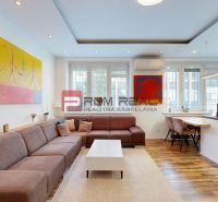 Wohnzimmer in einer 3-Zimmer-Wohnung mit einer Eckcouch und einem Boden in Holzoptik.