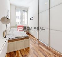 Schlafzimmer in einer 3-Zimmer-Wohnung mit Bett und Schrank, Boden mit Holzdekor.
