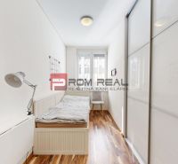 Helles Zimmer mit Bett, Sessel und Holzboden in einer 3-Zimmer-Wohnung.