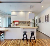 Küche in einer 3-Zimmer-Wohnung mit Holzboden, Möbeln und Bildern an der Wand.