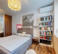 Schlafzimmer in einer 3-Zimmer-Wohnung mit Bett, Bücherregal und Holzboden.