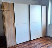 Das Ferienapartment enthält einen weißen Einbauschrank mit zwei Holztüren und einem Boden mit Holzdekor.