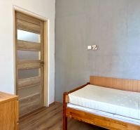 Ein Zimmer in einer 2-Zimmer-Wohnung mit einem Bett und einem Boden in Holzoptik.
