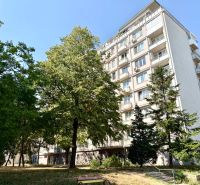 Ein Wohnhaus in der Piešťanská Straße in Bratislava - Nové Mesto, umgeben von Grünflächen und einer Bank.