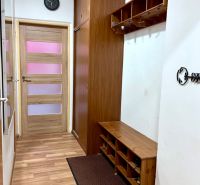 Eingangsflur mit Holzboden, Garderoben und Schrank in einer 2-Zimmer-Wohnung.