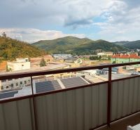 Blick vom Balkon einer 4-Zimmer-Wohnung in Nová Baňa auf die Berge und Gebäude.