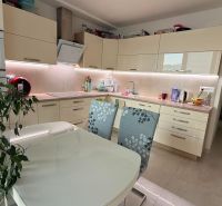 Küche in einer 4-Zimmer-Wohnung mit weißen Schränken und Esstisch.