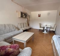 Wohnzimmer in einer 4-Zimmer-Wohnung mit einer bequemen Couchgarnitur und einem Boden in Holzoptik.
