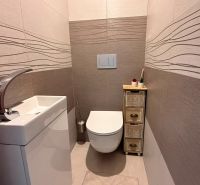 Gemütliche Toilette mit einfachem Waschbecken und dekorativen Fliesen in einer 4-Zimmer-Wohnung.