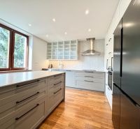 Helle Küche mit Kochfeld, Spüle und Boden mit Holzdekor in einer 3-Zimmer-Wohnung.