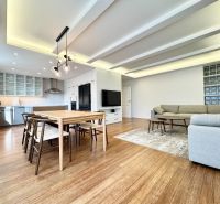 Wohnzimmer in einer 3-Zimmer-Wohnung mit Küche, Esstisch und Holzboden.