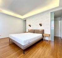 Schlafzimmer in einer 3-Zimmer-Wohnung mit einem Bett und einem Boden in Holzoptik.