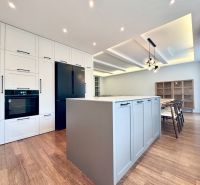 Küche mit Insel in einer 3-Zimmer-Wohnung, Boden mit Holzdekor, Esszimmer.