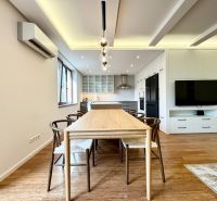 Küche in einer 3-Zimmer-Wohnung mit Beleuchtung, Holzboden und Esstisch.