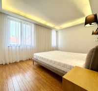 Schlafzimmer in einer 3-Zimmer-Wohnung mit Vorhängen und einem Boden in Holzoptik.