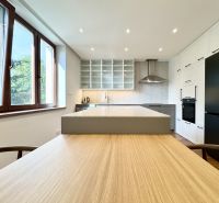 Küche in einer 3-Zimmer-Wohnung mit Insel und LED-Beleuchtung, Boden mit Holzdekor.