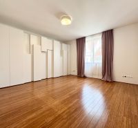 Ein geräumiges Zimmer in einer 3-Zimmer-Wohnung mit Holzboden und Einbauschränken.
