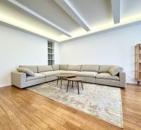 Wohnzimmer in einer 3-Zimmer-Wohnung mit einem Sofa, Teppich auf dem Boden mit Holzdekor.