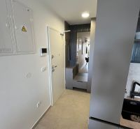 Eingangsflur in einer 3-Zimmer-Wohnung mit minimalistischem Design und Fliesen.