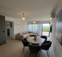 Wohnzimmer einer 3-Zimmer-Wohnung mit rundem Tisch, Sofa und Ausblick.
