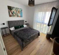 Schlafzimmer mit Bett, Kunstbild und Holzboden in einer 3-Zimmer-Wohnung.