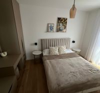 Schlafzimmer in einer 3-Zimmer-Wohnung mit Bett, Schrank und Boden mit Holzdekor.