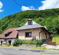 Ein älteres Haus mit Schrägdach in Mýto pod Ďumbierom, umgeben von Grün.