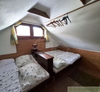 Dachzimmer mit zwei Betten und einem Boden mit Holzdekor in Geschäftsräumen.