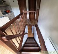 Ein Interieur mit einer Holztreppe neben der Küchenzeile und einem Boden mit Holzdekor.