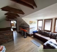 Dachgeschoss-Interieur mit Holzboden, Sitzgarnitur und Bartresen.