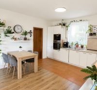 Küche in einer 3-Zimmer-Wohnung mit Pflanzen, Holzboden und Esstisch.