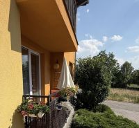 Der Balkon einer 3-Zimmer-Wohnung in Veľký Lapáš mit einem Geländer voller Blumen.