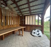 Ein Holzunterstand in Telince und eine 2-Zimmer-Wohnung mit Steinboden im Hintergrund.