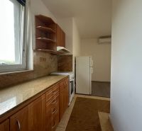 Küche in einer 2-Zimmer-Wohnung mit Arbeitsplatte aus Stein und Fenster.