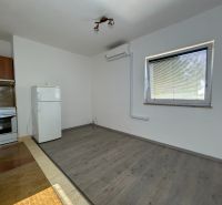 Küche in einer 2-Zimmer-Wohnung mit Holzboden, weißem Kühlschrank und Herd.