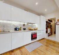 Küche in einer 3-Zimmer-Wohnung mit weißer Küchenzeile und Holzboden.