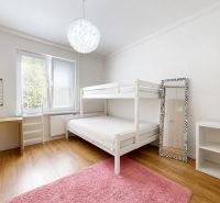 Kinderzimmer in einer 3-Zimmer-Wohnung mit Etagenbett, gelbem Stuhl, Regalen und Boden in Holzoptik.