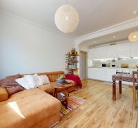 Wohnzimmer mit Küche in einer 3-Zimmer-Wohnung mit Holzboden.