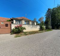 Ein Einfamilienhaus in der Školská-Straße in Tesárske Mlyňany mit blühenden Sträuchern am Zaun.