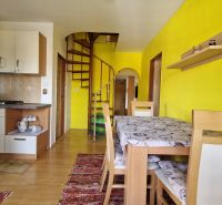 Küche in einer 2-Zimmer-Wohnung mit Holzboden und Wendeltreppe.