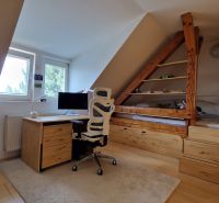 Dachbodenkantoor mit Schreibtisch, Stuhl und Holzboden in einer 2-Zimmer-Wohnung.