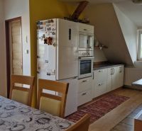 Küche in einer 2-Zimmer-Wohnung mit Holzboden und Esstisch.