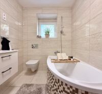 Elegantes Badezimmer in einer 2-Zimmer-Wohnung mit Badewanne, Waschbecken und Toilette.