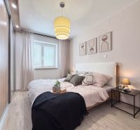 Schlafzimmer in einer 2-Zimmer-Wohnung mit Holzboden und Wanddekoration.